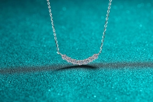 Close-up of S925 sterling silver smile necklace with seven sparkling round moissanite stones
