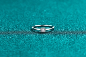 Macro shot of minimalist S925 silver ring featuring a square cut moissanite center stone