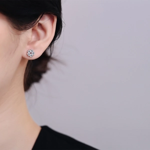 Elegant S925 sterling silver flower stud earrings with dark blue zircon on female model