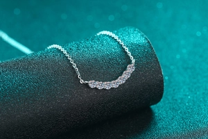 Close-up of S925 sterling silver necklace with seven-stone moissanite smile pendant