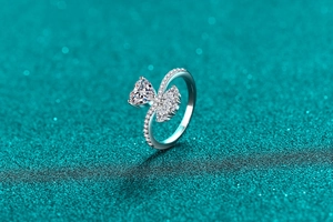 Macro view of heart-shaped moissanite ring with marquise accents on glitter background