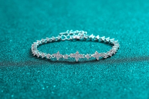 Macro shot of S925 sterling silver moissanite bracelet with four-leaf clover charms