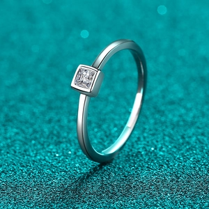 Minimalist S925 sterling silver ring with square-cut moissanite on a teal glitter surface