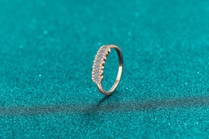Macro shot of rose gold ring with double rows of pavé-set moissanite stones