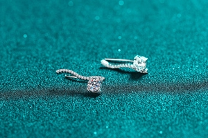 Macro shot of S925 sterling silver moissanite earrings with elegant wavy diamond pavé lines