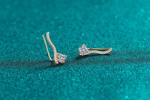 Détails macro de boucles d'oreilles vagues dorées avec moissanite cœur et micro-pavé