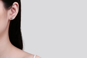 Close-up of S925 silver heart moissanite earrings on ear showing elegant curved design
