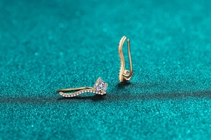 Détail de boucle d'oreille cœur en argent S925 avec finition or et pavé de pierres