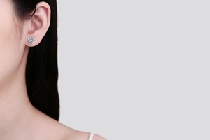Close-up of S925 sterling silver snowflake stud earring with moissanite on a female model