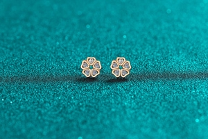 Macro shot of S925 silver flower stud earrings with moissanite on green glitter