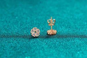 Macro shot of rose gold heart petal stud earrings with sparkling moissanite stones