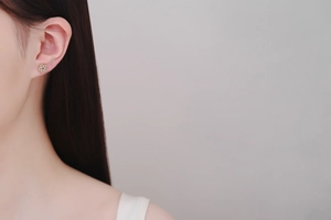 Detail view of S925 sterling silver petal earrings with champagne gold finish on model