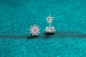 Macro view of sparkling moissanite snowflake stud earrings with silver butterfly backs