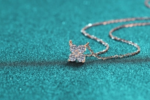 Macro shot of rose gold four-leaf clover pendant with sparkling moissanite stones