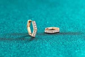 Detail of hexagonal rose gold earrings with micro-paved white zircon stones
