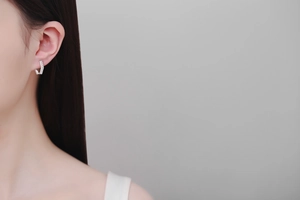 Gros plan de boucles d'oreilles hexagonales en argent 925 avec moissanite portée
