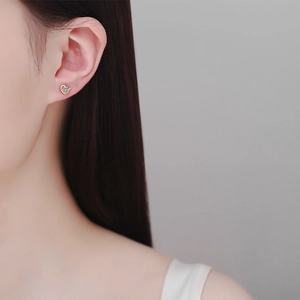 Elegant heart-shaped Moissanite stud earrings in champagne gold on a female model