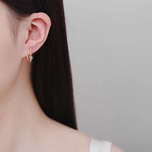 Minimalist irregular gold earrings with moissanite, elegant J-shape design on female model