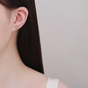 Elegant heart-petal flower stud earrings in champagne gold finish worn on ear