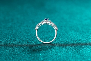 Macro detail of silver ring with oval blue gemstone and micro-paved cubic zirconia