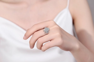 Close-up of a pear-cut moissanite ring with a V-shaped hollow design on a model's finger
