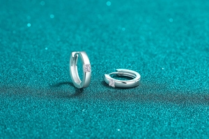 Macro detail of S925 sterling silver huggie earrings with princess cut moissanite stones