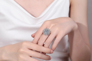 Macro view of pear-cut moissanite cluster ring with sparkling round halo and silver band