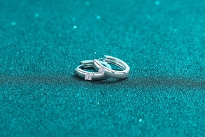 Close-up of S925 sterling silver hoop earrings featuring square-cut moissanite stones