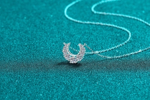 Macro shot of S925 sterling silver crescent necklace with sparkling moissanite stones