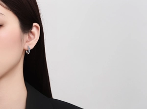 Close-up of S925 sterling silver hoop earrings with blue moissanite stones on model