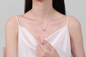Close-up of S925 sterling silver crescent necklace with blue moissanite on female neck