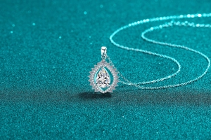Macro detail of S925 silver pear-shaped moissanite necklace with a halo teardrop pendant