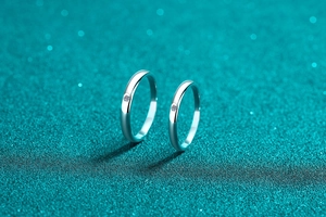 Macro shot of minimalist silver couple rings with brilliant center diamonds and polished finish