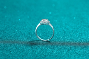 Detailed view of S925 silver moissanite ring with halo setting on glitter background