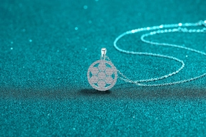 Macro shot of silver moissanite snowflake necklace pendant on a blue glitter background