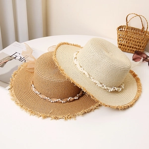 Flat top straw hats with pearl ribbons and frayed edges in brown and cream colors