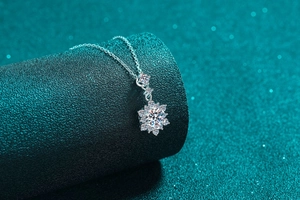 Macro detail of a 925 sterling silver snowflake pendant with moissanite on a texture base