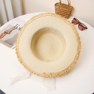 Flat top straw sun hat with fringe edge and white tulle ribbons for summer beach