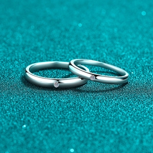 Polished S925 sterling silver couple rings with small stones on a blue background