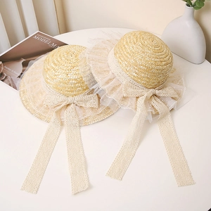Straw sun hat with white lace trim and bow ribbon in a minimalist lifestyle setting