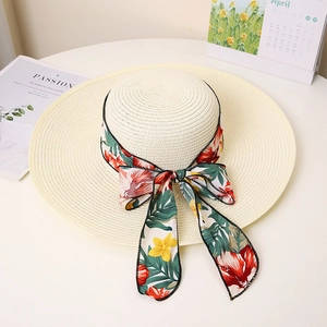 Detailed close-up of summer straw hat with colorful floral ribbon bow and wide brim