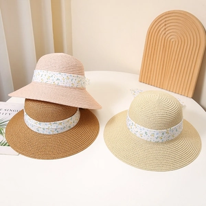 Summer straw sun hat with floral bow ribbon in pink, beige and brown colors
