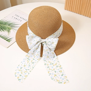 Detail of floral ribbon bow on woven straw hat for summer beach vacation sun protection