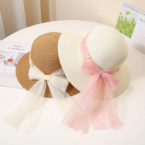 Women's straw sun hat with elegant pearl bow decoration in brown and cream beige