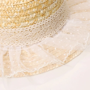 Macro detail of natural straw weaving with delicate white lace and polka dot mesh