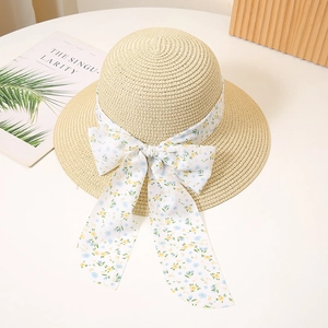 Detailed close-up of a summer straw hat with a blue and yellow floral ribbon bow