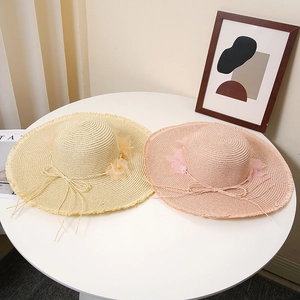 Women's wide brim straw hats in beige and pink with floral lace and tassels