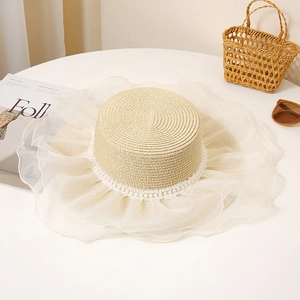 Detailed texture of flat top straw hat with pearl trim and organza pleated brim