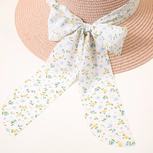 Detail of light pink straw hat with blue floral ribbon and elegant bow accent