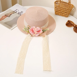 Detail of pink straw boater hat with floral lace ribbon and woven floral embellishment